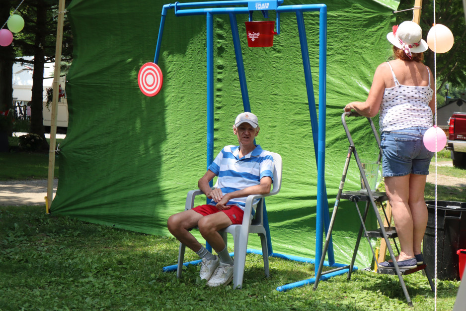 Dave Maxwell braves the dunk chair in front of a green backdrop