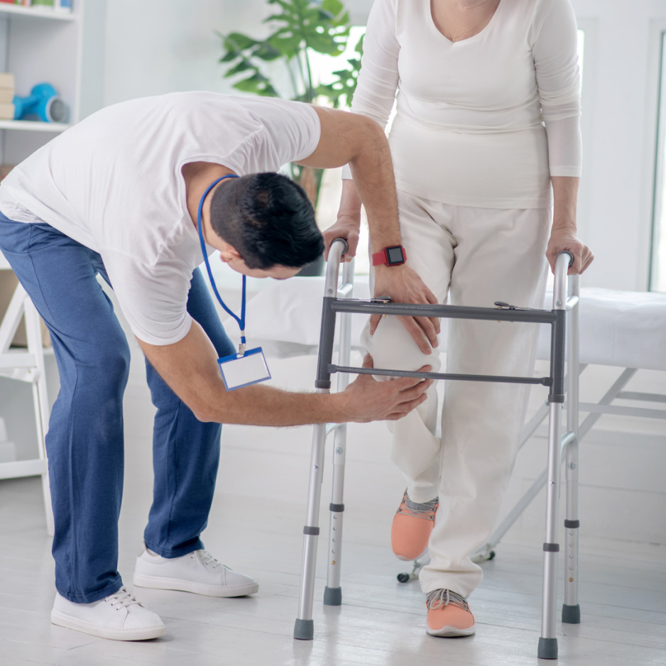 Lady with walker and a man helping her