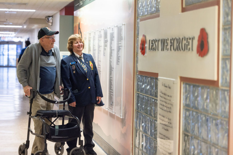 Two individuals look at the Hall of Heroes wall