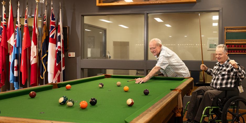 Two veterans playing pool at Parkwood Institute