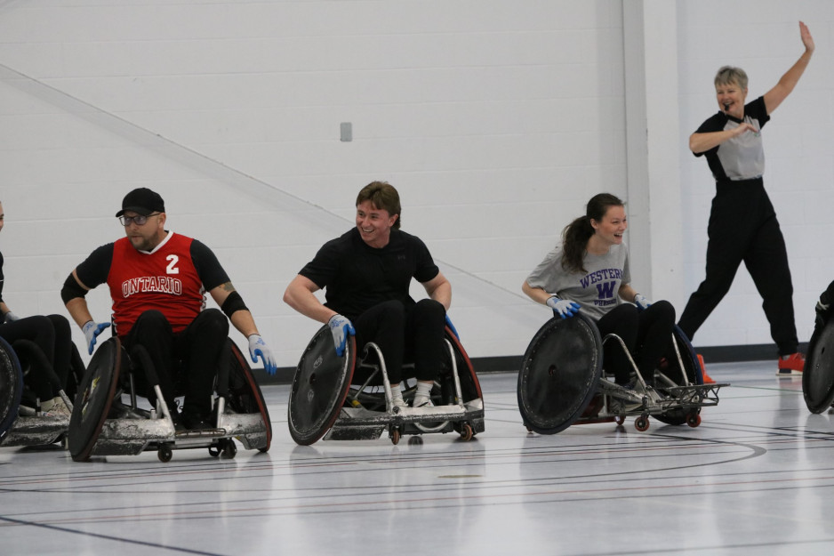 Three wheelchair rugby players prepare to play