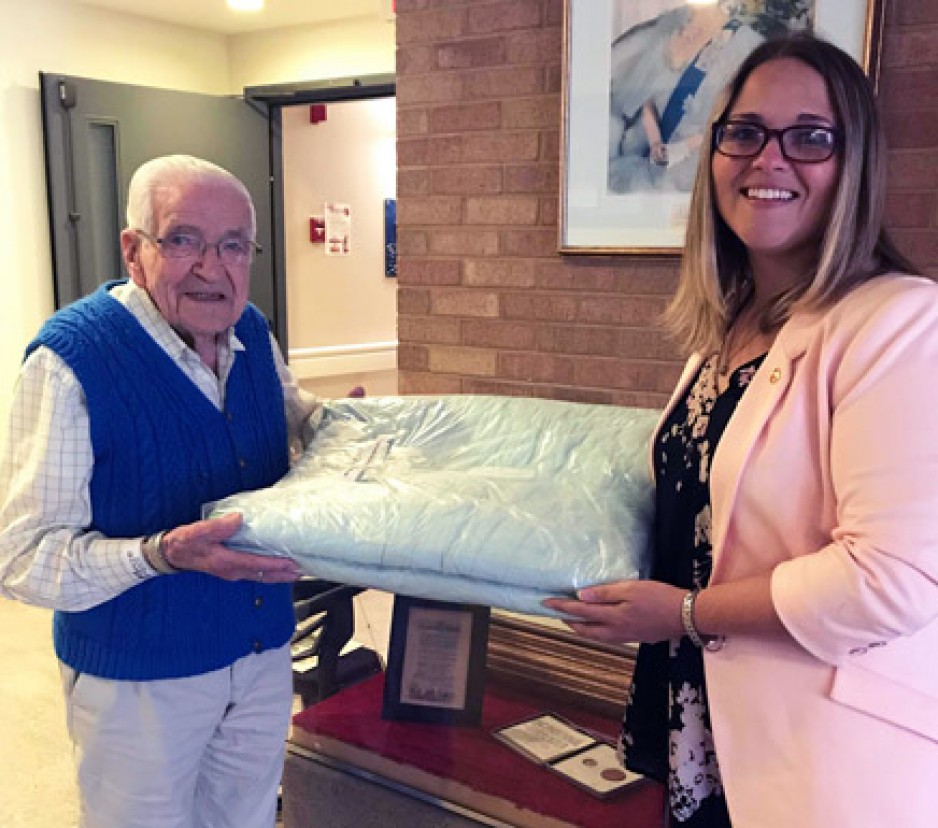 handing over the quilt for display