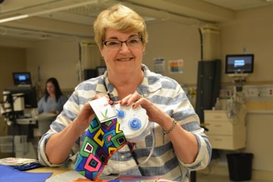 Sue Hickey, organizer of the Bag Ladies outreach project, demonstrates use of the bags, which are designed to hold the surgical drains and tubes required by breast cancer patients after surgery. The Bag Ladies, all members of Canadian Embroiderers’ Guild, London, make and donate about 400 of the bags every year to St. Joseph’s Hospital.   