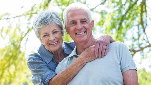 elderly couple with arms around each other