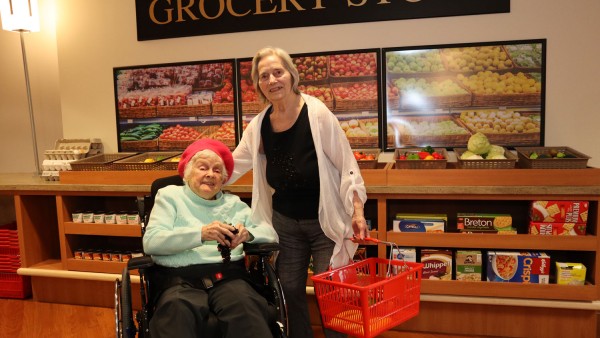 two elderly women in front of grocery store at the interactive village