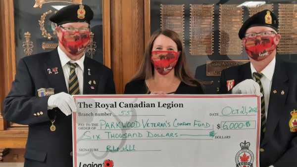 three people holding large cheque