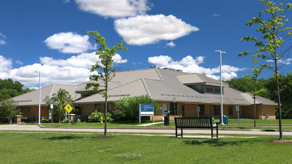 exterior of a brick building on the grounds of Parkwood Institute surrounded by green grass and blue sky