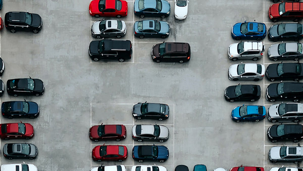 an aerial view of a parking lot with cars parked in marked spaces