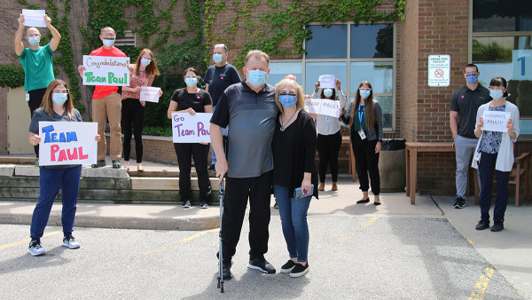 Paul Garrett and his wife surrounded by his care team outside of Parkwood Institute
