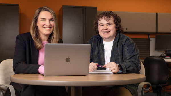 Dr. Arlene MacDougall and Alec Cook sit down with a laptop computer