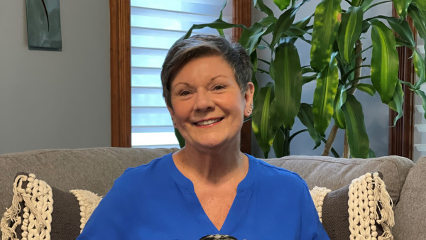 Helen Berner sitting on a couch with three dachshund dogs