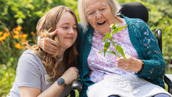 Resident at Mount Hope with staff in the garden