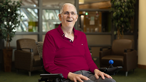 Bill sited on his wheel chair smiling