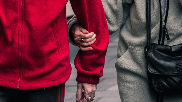 elderly couple holding hands