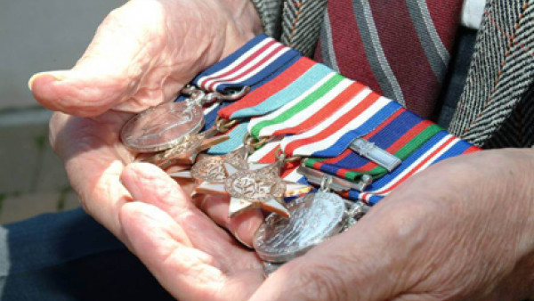 Veteran holding war metals in hands