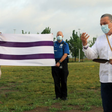 Bill Hill (Ro'nikonkatste) gesturing toward the Wampum flag