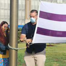 Belinda King, a client of the Biigajiiskaan program, raises the Wampum flag