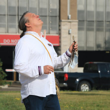 Bill Hill (Ro'nikonkatste) gesturing toward the raised Wampum flag
