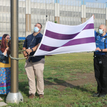 Belinda King, a client of the Biigajiiskaan program, raising the Wampum flag