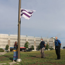Wampum flag being raised up the flag pole at Parkwood Institute