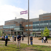 Wampum flag being raised with Parkwood Institute in the background