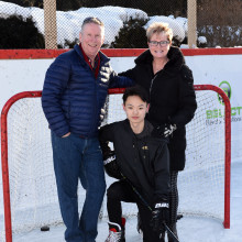 Jill Chapman poses with her husband and son on a hockey rink