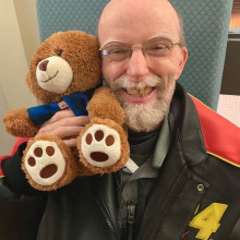 man holding up a teddy bear