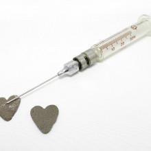 two heart-shaped sharpening stones placed in front of a needle