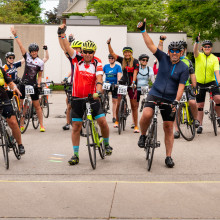 cyclists with hands in the air