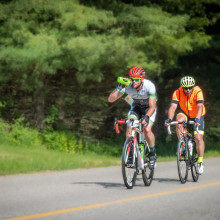 cyclists traveling down road