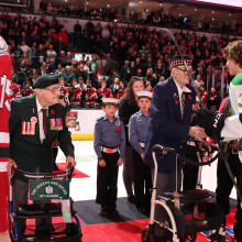 Jack Byrne and Corporal George Herbert Beardshaw shaking hands with the hockey players
