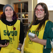 Two volunteers holding moneris machines