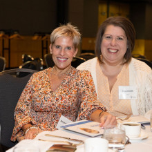 two women sitting together at a table