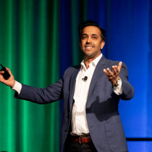 A man (Neil Pasricha) standing on stage at a podium