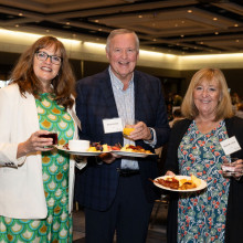 Three people holding up their breakfast plates from the buffet