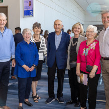 Seven people posing for a photo at an event
