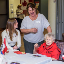 three woman around a table talking and laughing