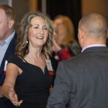 a woman reaches out to greet someone at a fundraising gala