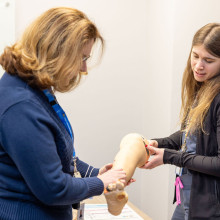 two woman looking at simulation leg