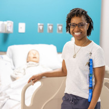 woman poses with bed and mannequin