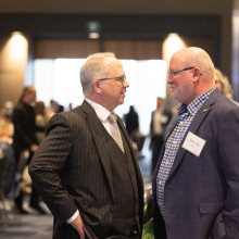 Two men in suits speaking