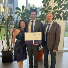 Three people stand together smiling