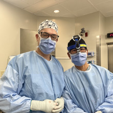 Two health care providers in masks and scrubs