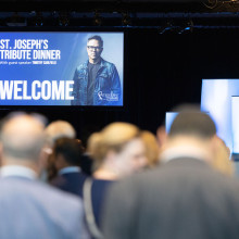 A crowd files into a room for the 2025 Tribute Dinner