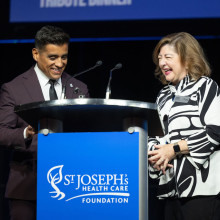 Alfonso Campos Reales and Michelle Campbell smile at the podium