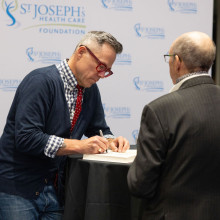 Timothy Caulfield gladly signs one of his books for an event guest