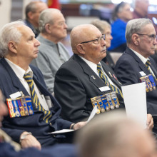 Veterans, servicemen and servicewomen sit in attendance
