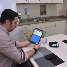 Man sitting at table holding tablet