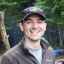 Mitch Kuska smiling with trees behind him