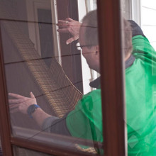 A man moving a piece of furniture through a doorway